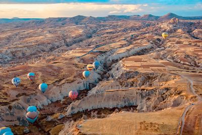 Aerial view of hot air balloons flying above mountains