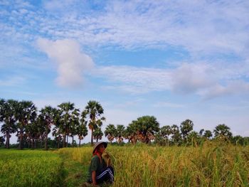 Rear view of man on field against sky