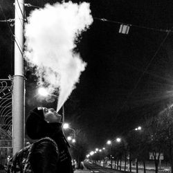 Woman in illuminated city at night