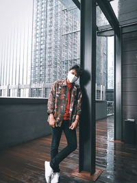 Full length of young man looking at building in city