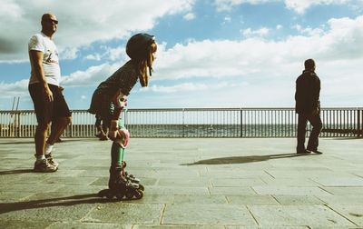 Full length of woman standing by railing against sky