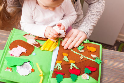 High angle view of girl holding toy on table