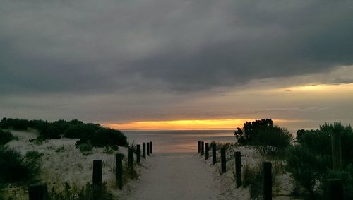 Scenic view of sea against cloudy sky during sunset