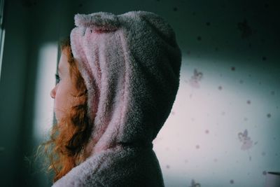 Thoughtful girl in bedroom looking away