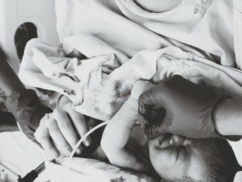Cropped image of doctors working on newborn baby in hospital