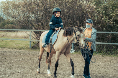 A child with special needs is riding with a close supervision teacher. 