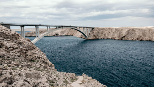 Arch bridge over sea against sky