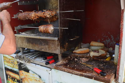 Person preparing kokorec turkish famous meal, street food on barbecue grill