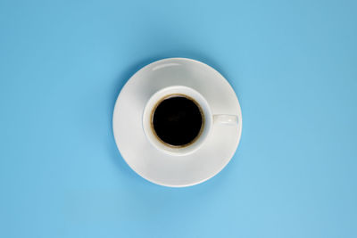 Directly above shot of coffee cup against blue background