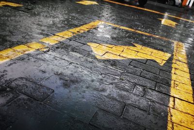 Close-up of arrow symbol on wet road