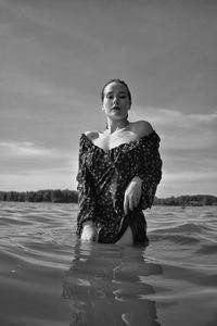 Portrait of woman standing in sea against sky