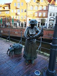 Statue on street against buildings in city