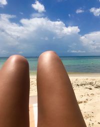 Low section of woman relaxing on beach