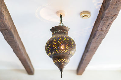 Low angle view of lighting equipment hanging on ceiling