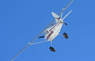 Low angle view of airplane against clear blue sky