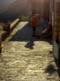 Rear view of woman walking in narrow street