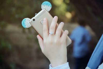 Cropped hand of woman holding smart phone