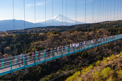 High angle view of people walking on footpath over forest against sky