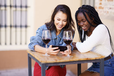 Portrait of a beautiful young woman drinking glass on table