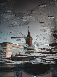 Reflection of building in frozen river