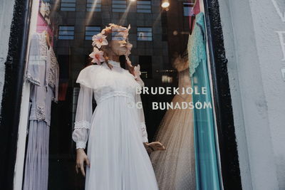 Woman standing by window in city