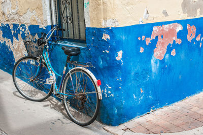 Bicycles on sidewalk against wall