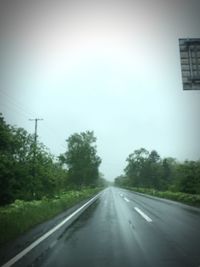 Empty road along trees