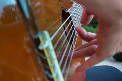 Close-up of person hand playing guitar