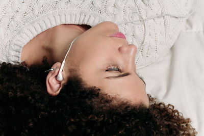 Woman listening music on bed at home
