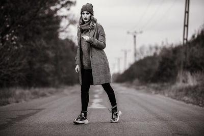 Full length portrait of woman standing on road