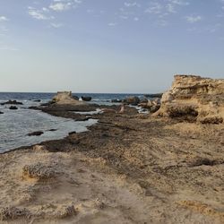 Rocks on beach against sky