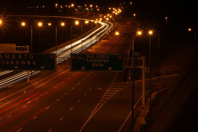 Empty road along lit street lights at night