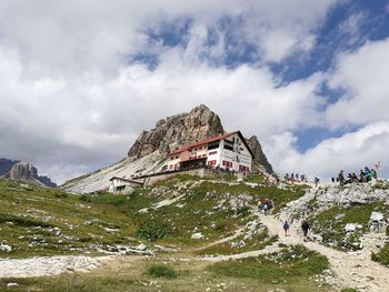 Low angle view of mountain and mountain hut against sky