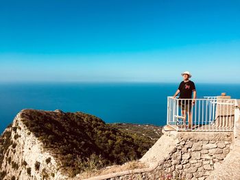 Man standing by sea against blue sky