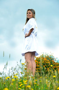 Full length of happy girl standing on field against sky