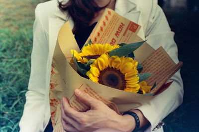 Midsection of woman holding bouquet