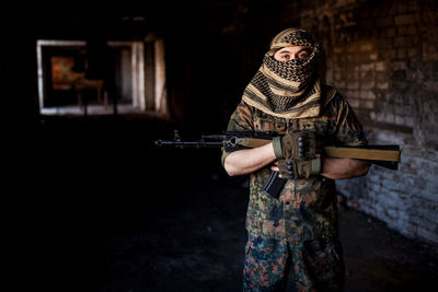 Portrait of serious middle eastern man with ak-47