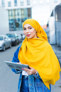 Portrait of young woman standing in city