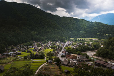 High angle view of townscape by mountain against sky