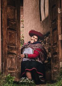 Portrait of girl sitting on door