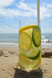 Close-up of juice in glass on beach