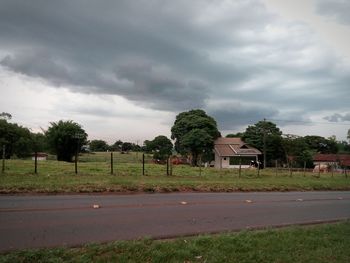 Trees and houses against storm clouds