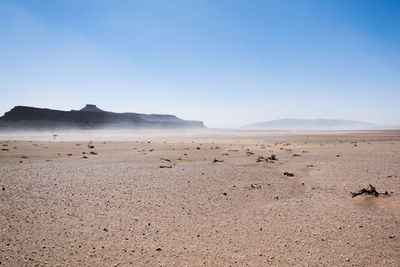 Scenic view of desert against clear blue sky