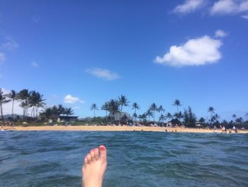 Low section of people standing on beach