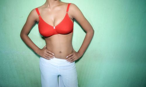 Midsection of woman standing against wall