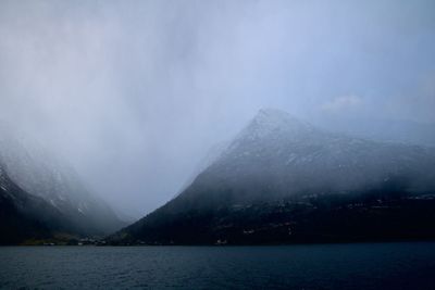 Scenic view of lake and snowcapped mountains against sky