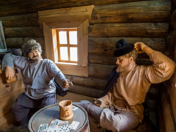 Full length of man sitting by window