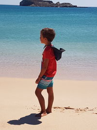 Full length of boy on beach against sky