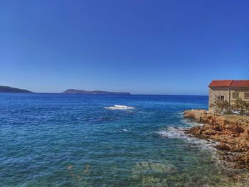 Scenic view of sea against clear blue sky