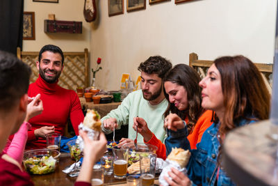 Happy friends sitting on table